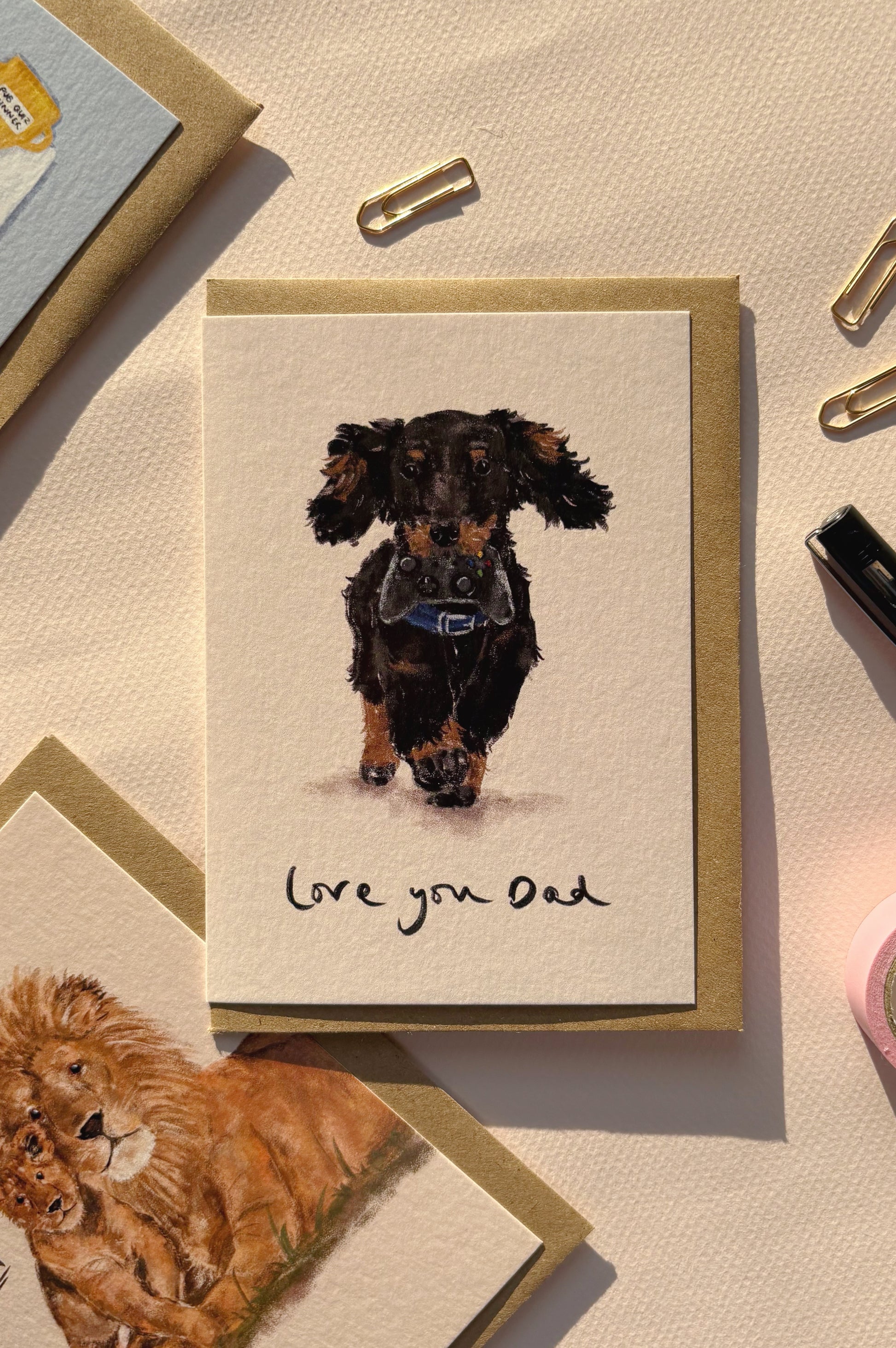 Card with a dachshund illustration and 'Love you Dad' text on a textured surface.